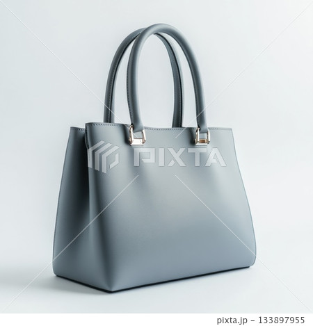 Stylish gray handbag with sleek design and dual handles displayed on a soft background 133897955