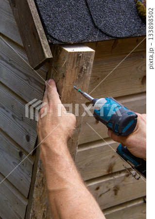 Handyman installing a wooden rabbit house 133898502
