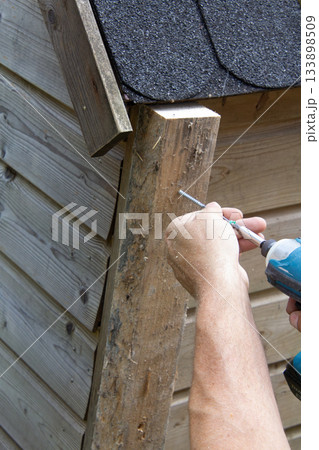 Handyman installing a wooden rabbit house 133898509