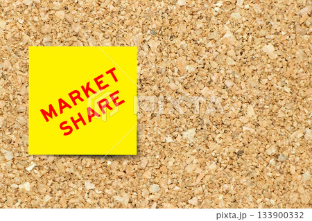 Yellow note paper with word market share on cork board background with copy space 133900332