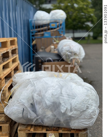 Pile of garbage bags sits on top of a wooden pallet Pile of garbage bags sits on top of a wooden pallet 133901091