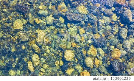 Aerial Clear River Water and Colorful Rocks Top Down View Aerial Clear River Water and Colorful Rocks Top Down View 133901229
