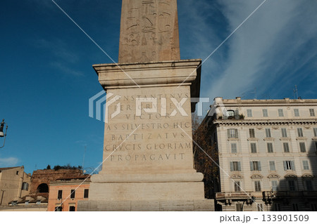 Lateran Obelisk in Piazza San Giovanni in Laterano Rome under blue sky ancient Egyptian granite monument with Latin base inscriptions city square landmark travel Italy. High quality photo 133901509