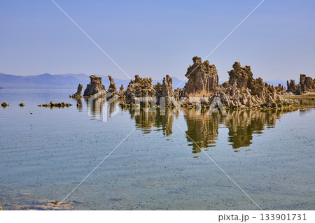 Mono Lake Tufa Formations Reflected in Calm Water with Distant Mountains 133901731
