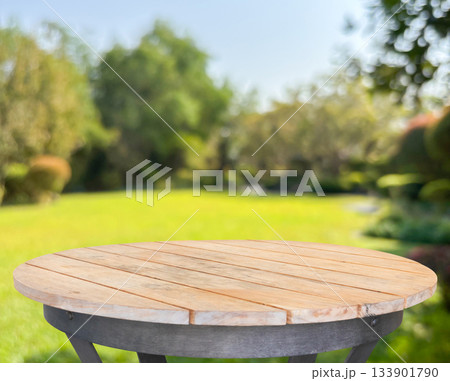 Empty round wood table top with abstract blur park garden background 133901790