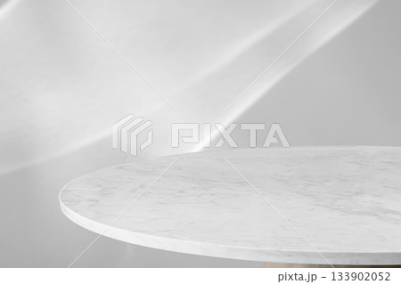 Round marble table top with abstract shadow drop on white wall background for mockup product display 133902052