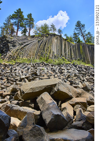 Basalt Columns and Broken Rocks at Devils Postpile in California Under Blue Sky 133902121