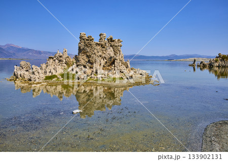 Mono Lake Tufa Formations Reflected in Calm Water with Distant Mountains and Blue Sky Mono Lake Tufa Formations Reflected in Calm Water with Distant Mountains and Blue Sky 133902131
