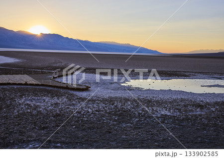 Badwater Basin Salt Flats Boardwalk and Water Pool at Sunset in Death Valley Badwater Basin Salt Flats Boardwalk and Water Pool at Sunset in Death Valley 133902585
