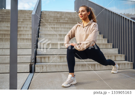 Fitness woman in fashionable sportswear is doing sports outdoors. The concept of active lifestyle. 133905163