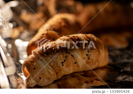 Handcrafted buttery croissant with golden flaky layers and inviting bakery atmosphere 133905426