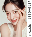 美肌で綺麗な女性が頬に手を当てて微笑む縦型の美容ポートレート 133906137