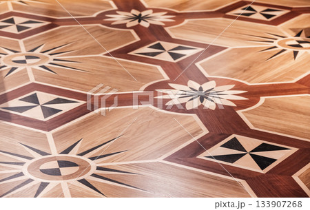 Wooden parquet with different wood types create intricate geometric pattern Wooden parquet with different wood types create intricate geometric pattern 133907268