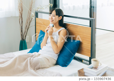 ベッドでスマホを見る若い女性 133907436