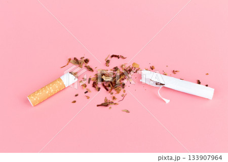 cigarette butts torn on pink background 133907964