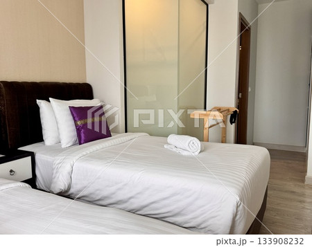 There is a double bed in the hotel room with neatly made bed linen and towels 133908232