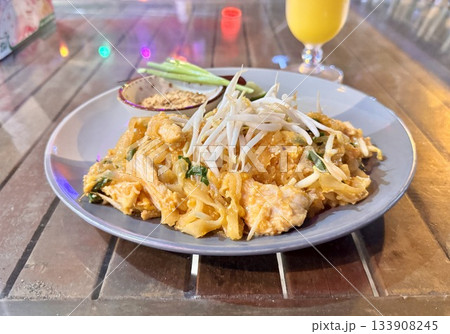 Delicious fresh Thai pad thai with chicken in an outdoor cafe Delicious fresh Thai pad thai with chicken in an outdoor cafe 133908245
