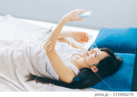 ベッドでスマホを見る若い女性 133908270
