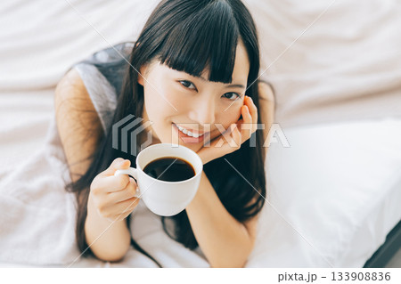 ベッドでコーヒーを飲む女性 ベッドでコーヒーを飲む女性 133908836