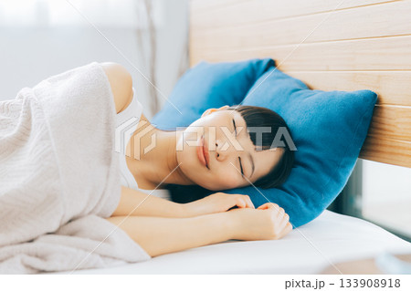 ベッドで寝る女性 133908918