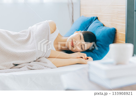 ベッドで寝る女性 133908921