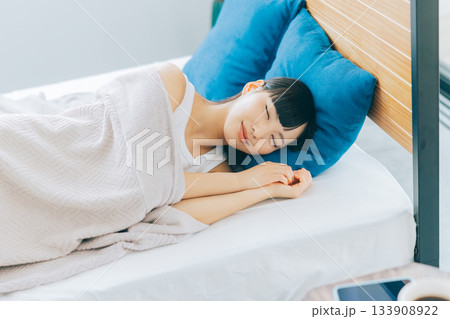 ベッドで寝る女性 133908922