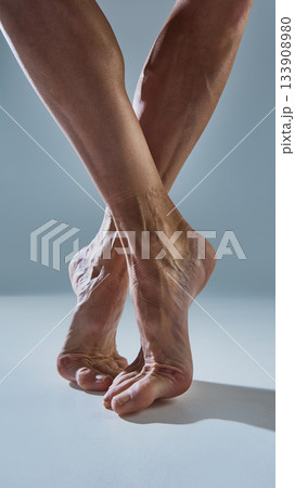 Bare ballet feet on demi-pointe revealing emotional raw strength and texture 133908980