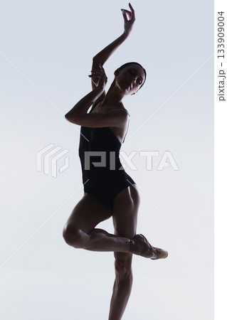 Upper-body portrait of ballerina in raised expressive arm pose. 133909004