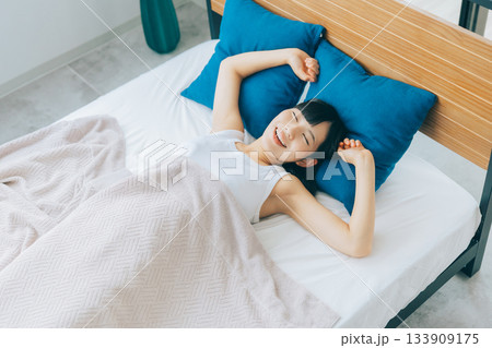 朝ベッドで目覚めた若い女性 133909175