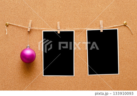 Empty photos and Christmas tree toys are pinned on a cork board. Copy space 133910093