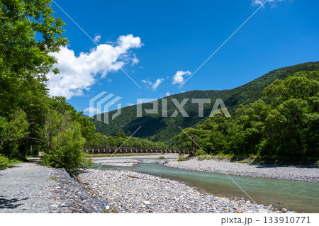 Myojin Bridge and mountains along Kamikochi hiking trail, Japan Myojin Bridge and mountains along Kamikochi hiking trail, Japan 133910771