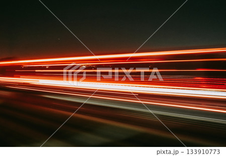 Light trails of a moving vehicle at night on the road Light trails of a moving vehicle at night on the road 133910773