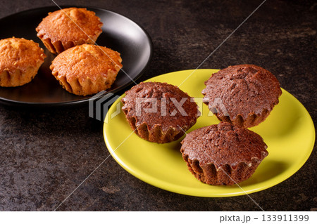 Delicious chocolate and lemon muffins ready to indulge on plates Delicious chocolate and lemon muffins ready to indulge on plates 133911399