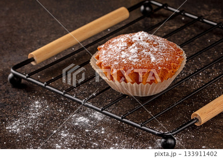 Freshly baked lemon muffin with a bright yellow hue on black background 133911402