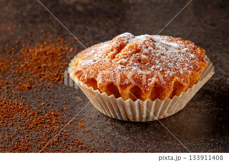 delicious cupcake in a paper baking form against a black background delicious cupcake in a paper baking form against a black background 133911408