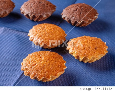 Delicious muffins displayed on a blue napkin background in frontal view Delicious muffins displayed on a blue napkin background in frontal view 133911412