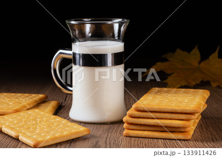 Refreshing milk and tasty crackers arranged on a vintage kitchen table 133911426
