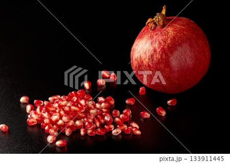 Beautiful close-up of splendid pomegranate seeds on dark surface Beautiful close-up of splendid pomegranate seeds on dark surface 133911445