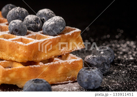 Satisfy your cravings with soft belgian waffles, blueberries, and sugar dust Satisfy your cravings with soft belgian waffles, blueberries, and sugar dust 133911451
