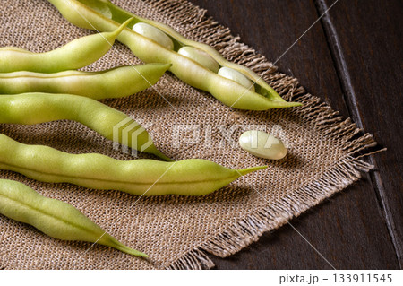 Close-up of asparagus beans on a rustic burlap napkin for culinary presentation 133911545