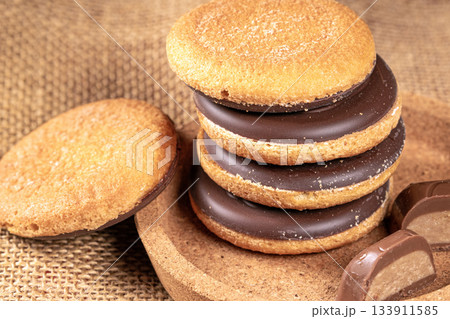 Delicious stack of chocolate cookies piled on a rustic burlap napkin Delicious stack of chocolate cookies piled on a rustic burlap napkin 133911585