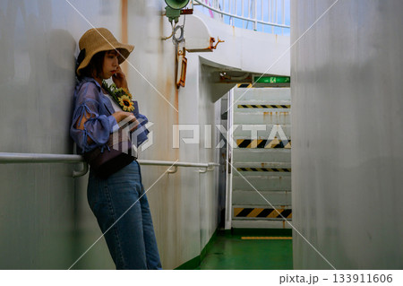 隠岐の島へ向かうフェリー船内通路で佇む女性 133911606
