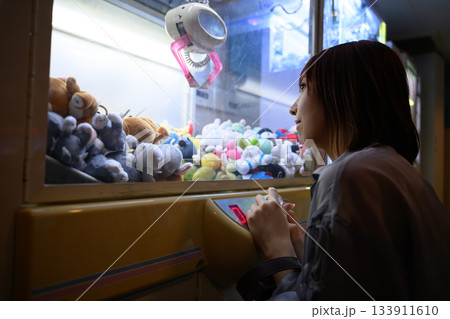 フェリー船内のゲームセンターでクレーンゲームに挑戦する女性 133911610
