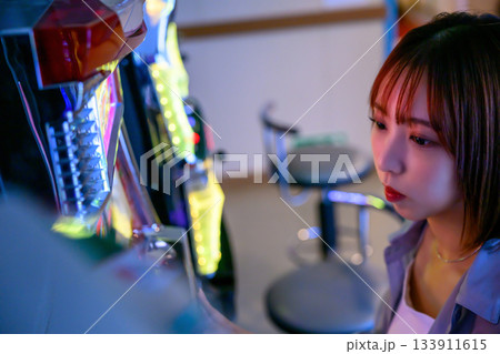 フェリー船内のゲームセンターでスロットに興じる若い女性 133911615