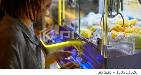 クレーンゲームに熱中する女性の横顔 133911620