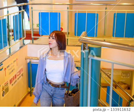 フェリー船内で階段に立つ若い女性のポートレ 133911632