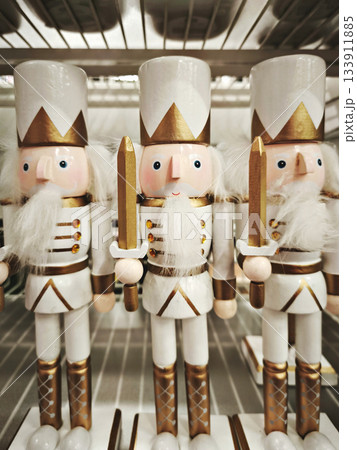Line of wooden white nutcracker figures with crowns and uniforms on shelf, cheerful winter mood 133911885