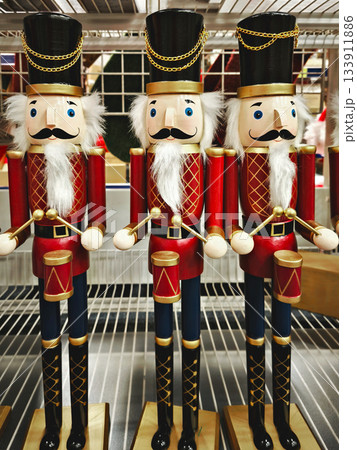 Traditional wooden red and gold nutcracker guards in uniform, bright festive holiday vibe Traditional wooden red and gold nutcracker guards in uniform, bright festive holiday vibe 133911886