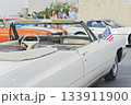 White vintage convertible with small American flag at outdoor car meet, open top and chrome details, sunny day mood 133911900