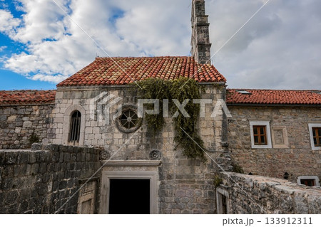 Wide-angle view of Santa Maria in Punta, one of the oldest churches in Budva, Montenegro, situated in the historic Old Town. Shows the full structure, surrounding narrow streets, and Mediterranean Wide-angle view of Santa Maria in Punta, one of the oldest churches in Budva, Montenegro, situated in the historic Old Town. Shows the full structure, surrounding narrow streets, and Mediterranean 133912311